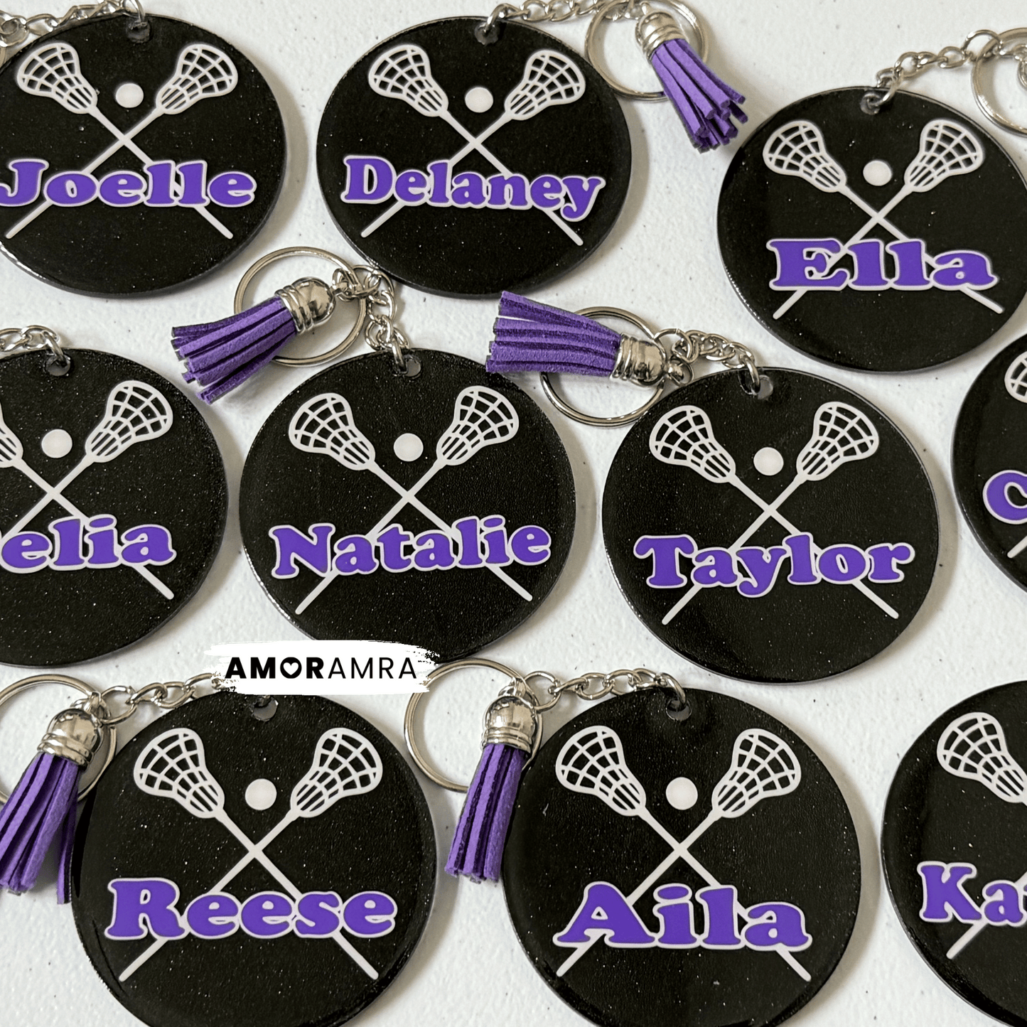 Black keychains with lacrosse designs and personalized names on a white background