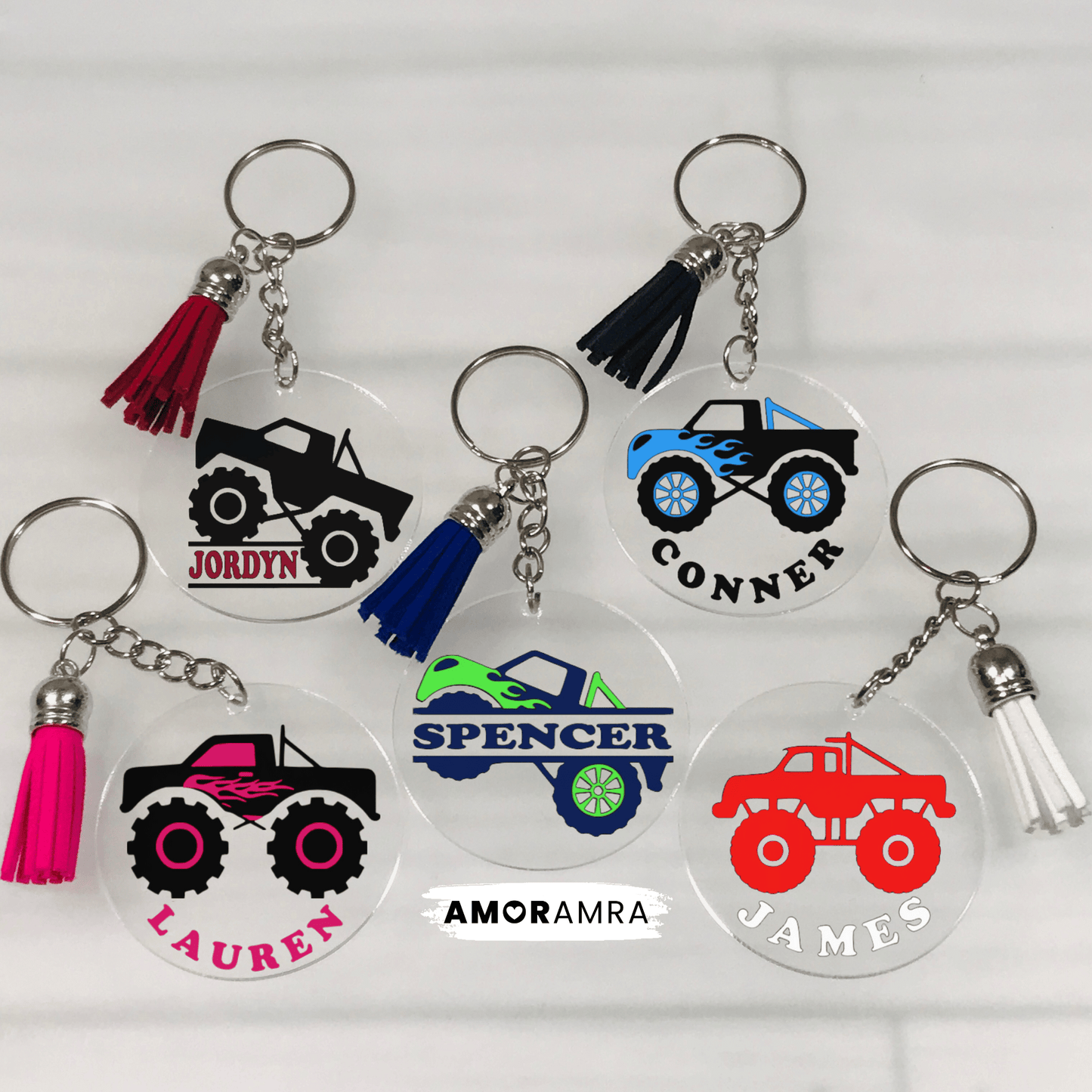 Five personalized keychains with monster truck designs and names on a white background. clear acrylic keychains with monster truck designs and tassels. The monster trucks are black, blue, green, pink, and red. Personalized Monster Truck Keychain, Monster Truck Bag Tag, Custom Monster Truck Gift, Big Truck Gift, Big Wheel Trucks, Truck For Girls