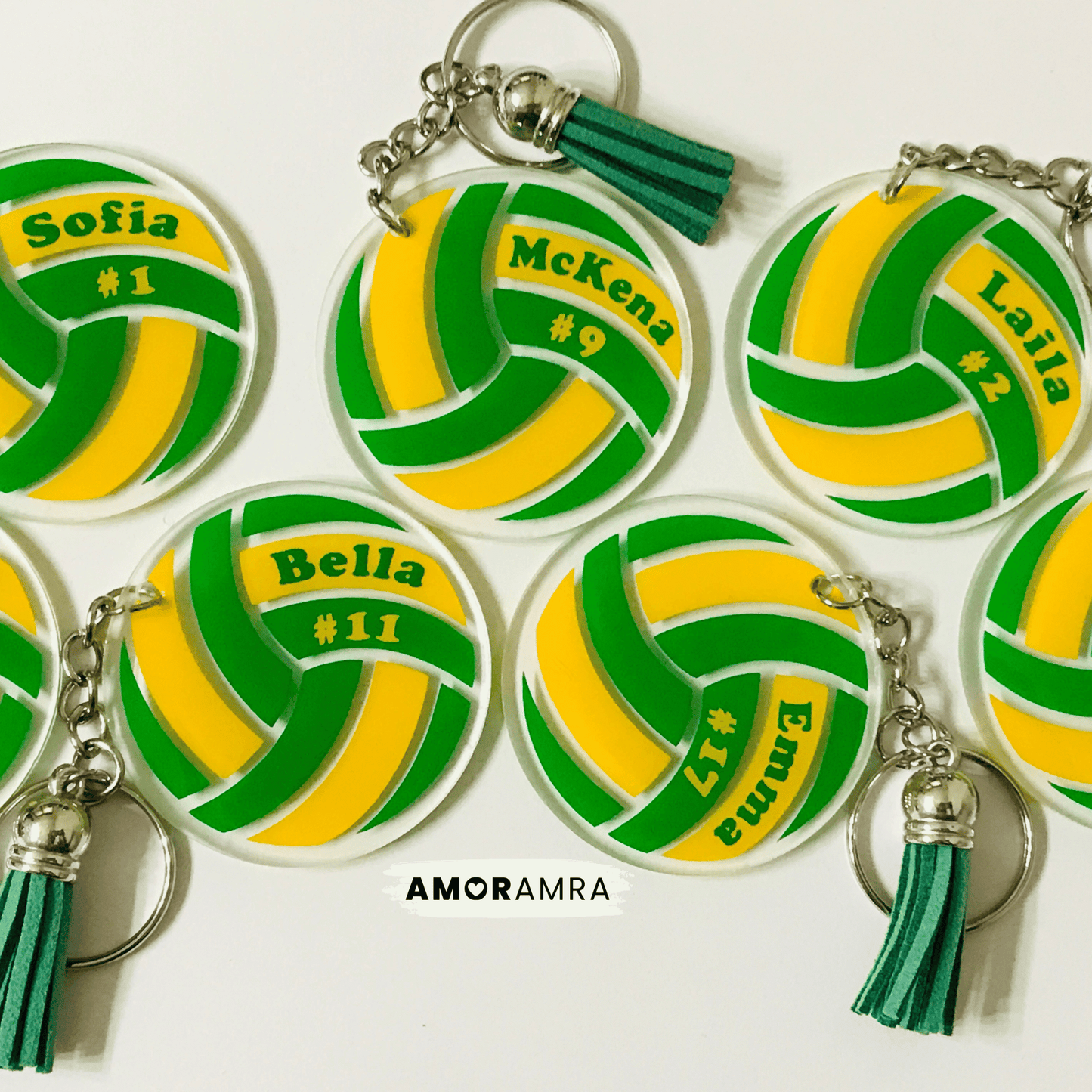 Volleyball-shaped keychains with personalized names and numbers on a white background, featuring the brand 'AMORAMRA'.