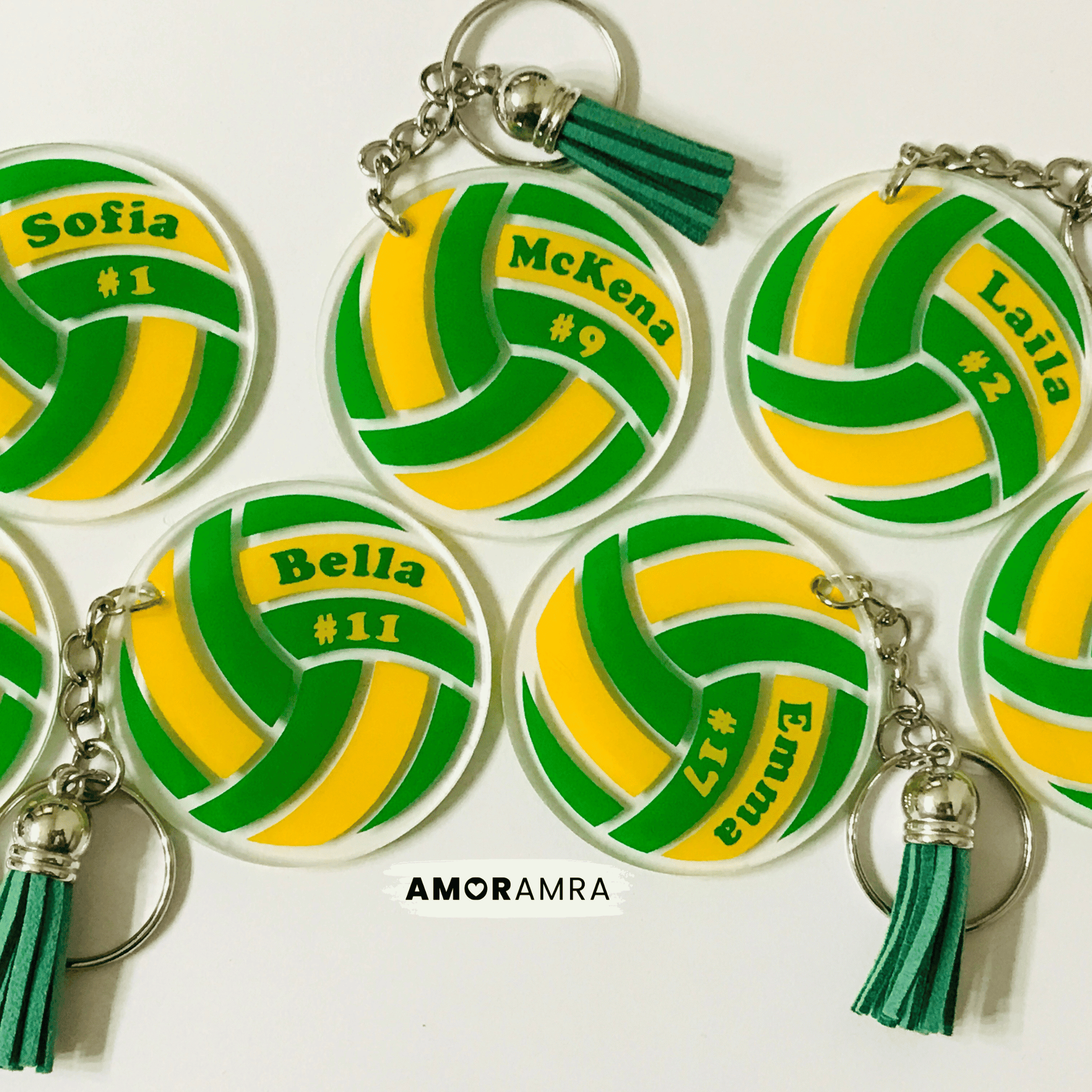 Volleyball-shaped keychains with personalized names and numbers on a white background, featuring the brand 'AMORAMRA'.