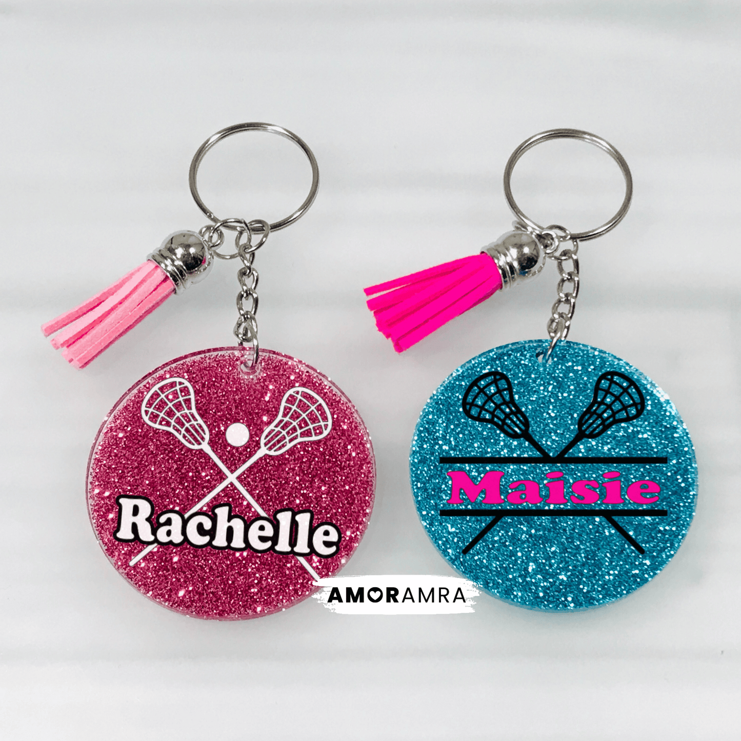 Two keychains with lacrosse designs .