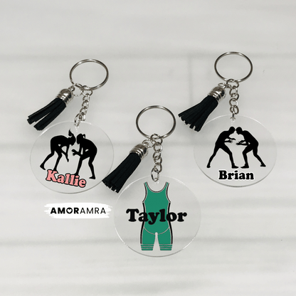 Three keychains with wrestling-themed designs and names on a white background